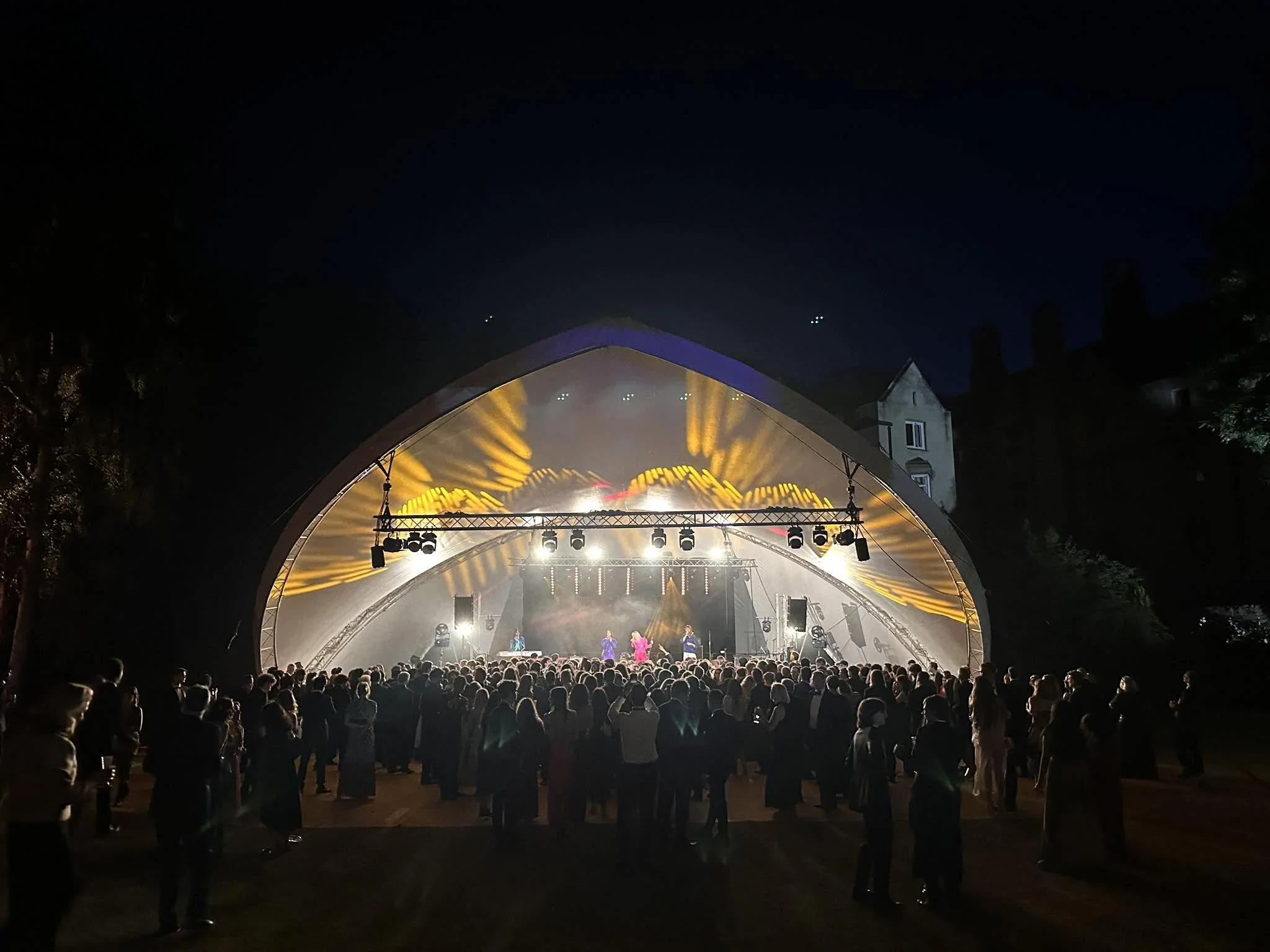 Crowd watching a live performance on a covered outdoor stage