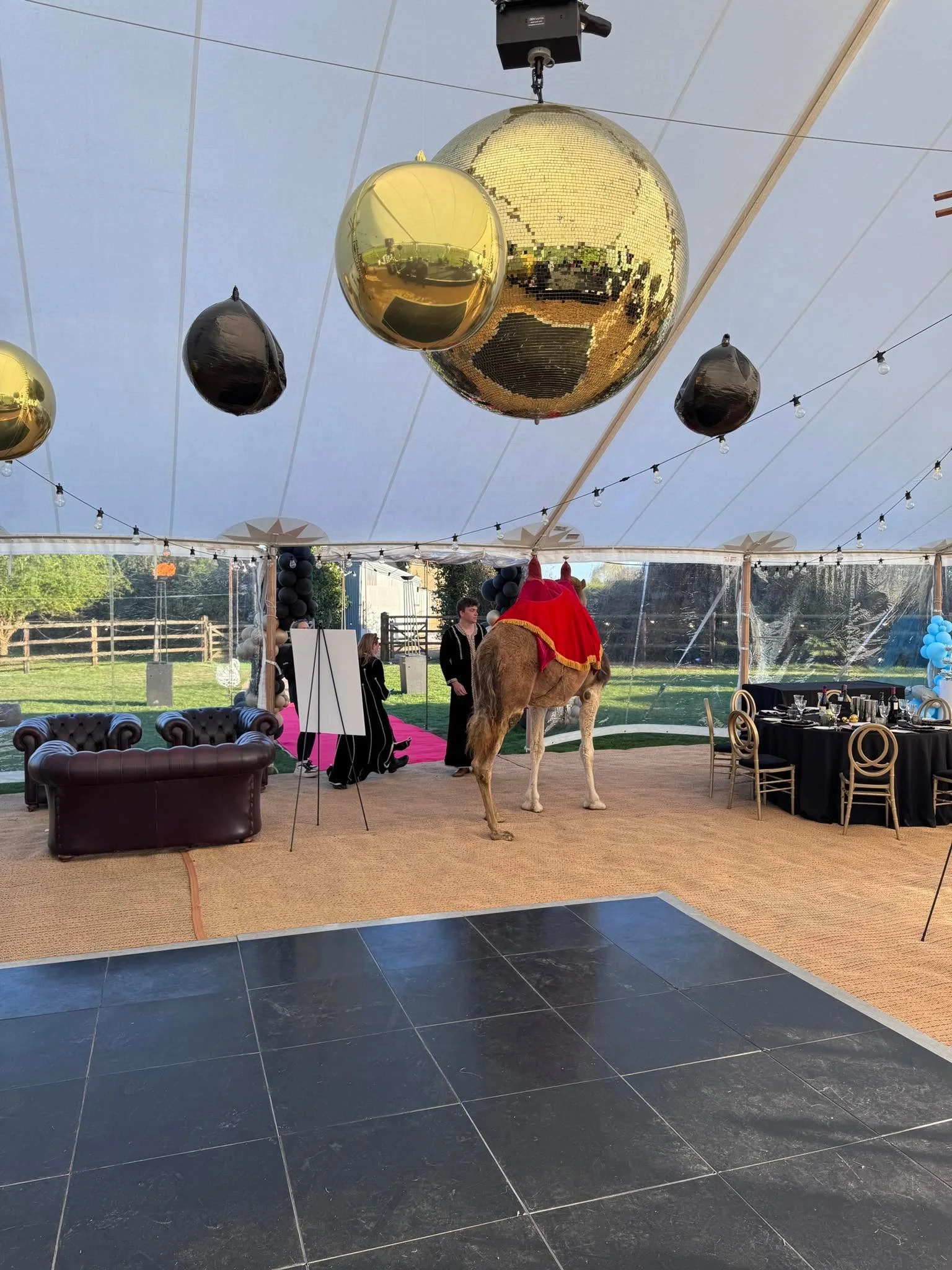 Private event marquee with suspended mirror balls and themed entertainment